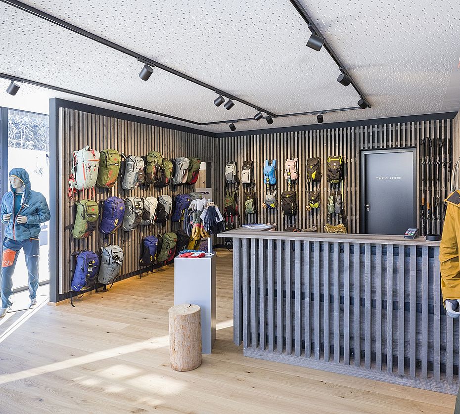 Sportartikel-Showroom mit Holzlamellenverkleidung Rucksäcken und Outdoor-Bekleidung