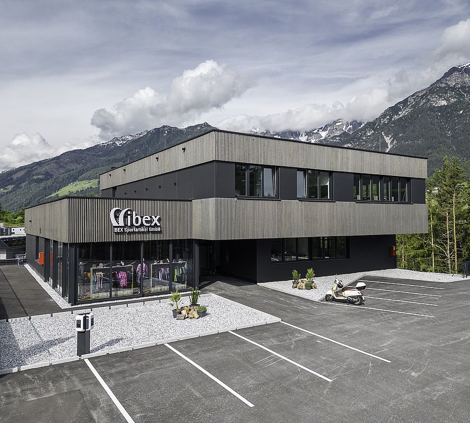 IBEX-Sportartikelgebäude mit Holzfassade und Showroom-Glasfront im Sommer