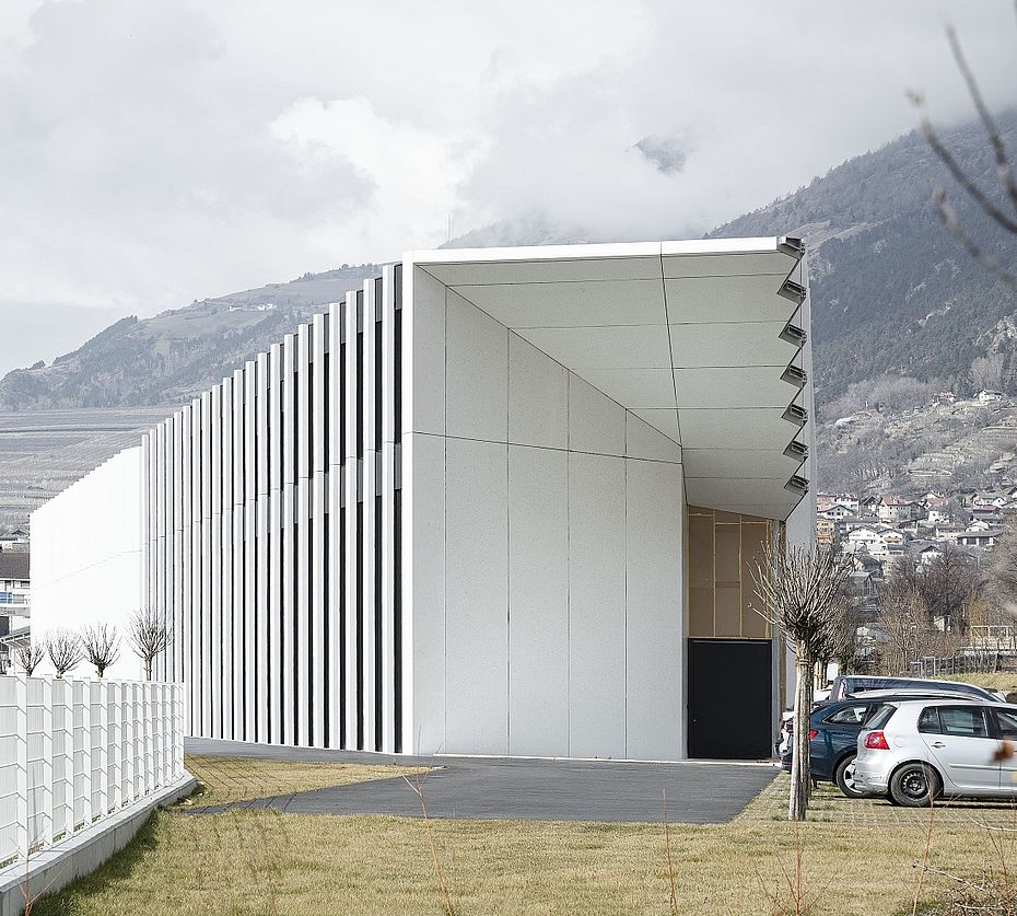 Edificio industriale moderno con facciata a lamelle nella valle sudtirolese con vigneti